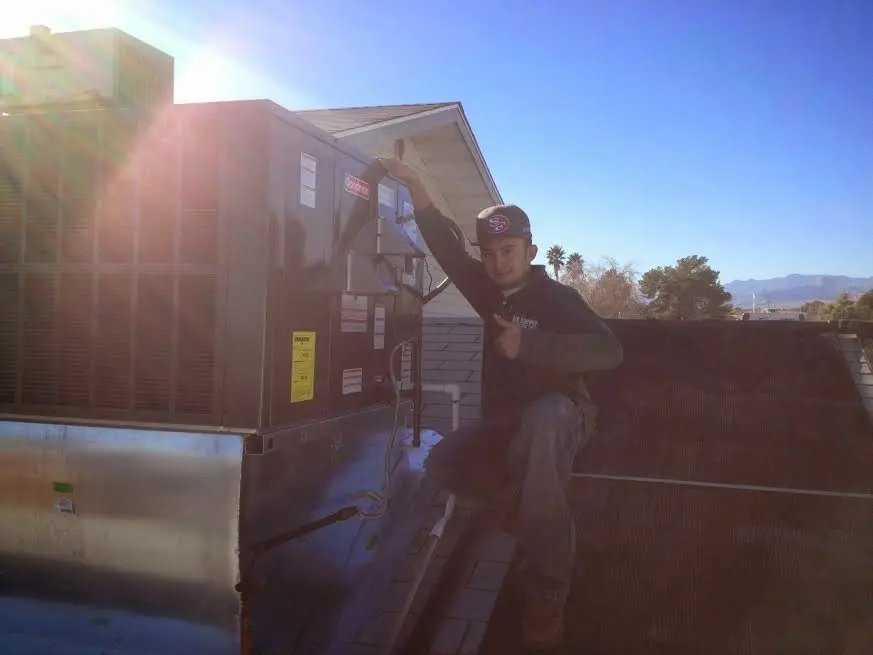HVAC technician performing AC Tune-Up on a rooftop unit in Woodstock